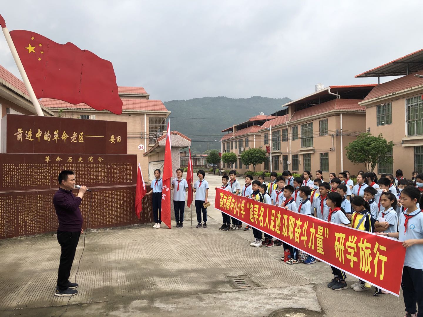 3月30日上午，寨岗镇中心小学党总支部组织部分党员、教师，少先队大队部学生干部，学校纪律卫生文明评比学生及高年级各班优秀学生代表共100人到寨岗镇金鸡桅杆村祖屋祠堂、安田海螺墩村革命遗址、安田安居新村开展以“追寻名人足迹，汲取奋斗力量”为主题的研学旅行活动.jpg
