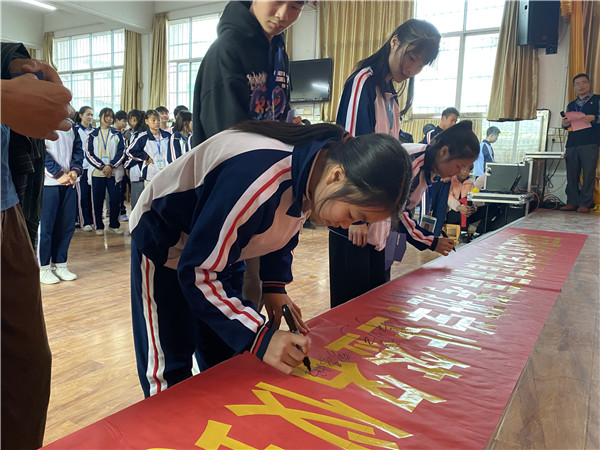 图五：高考班学生在出征横幅上签名.png